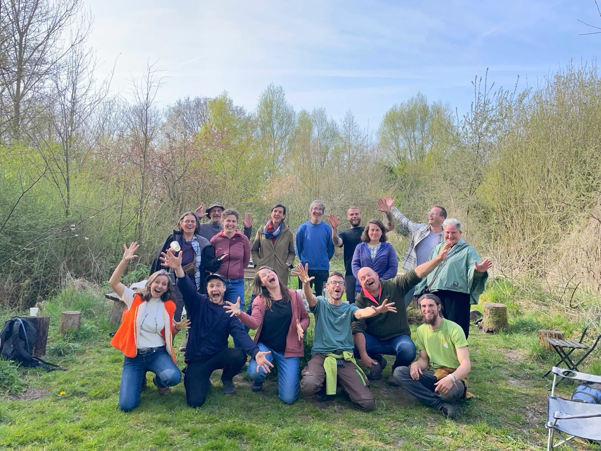 La promotion 2024-2025, bras levés dans un jardin-forêt au printemps